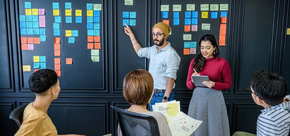 Equipo dando forma a una idea con notas en una pizarra