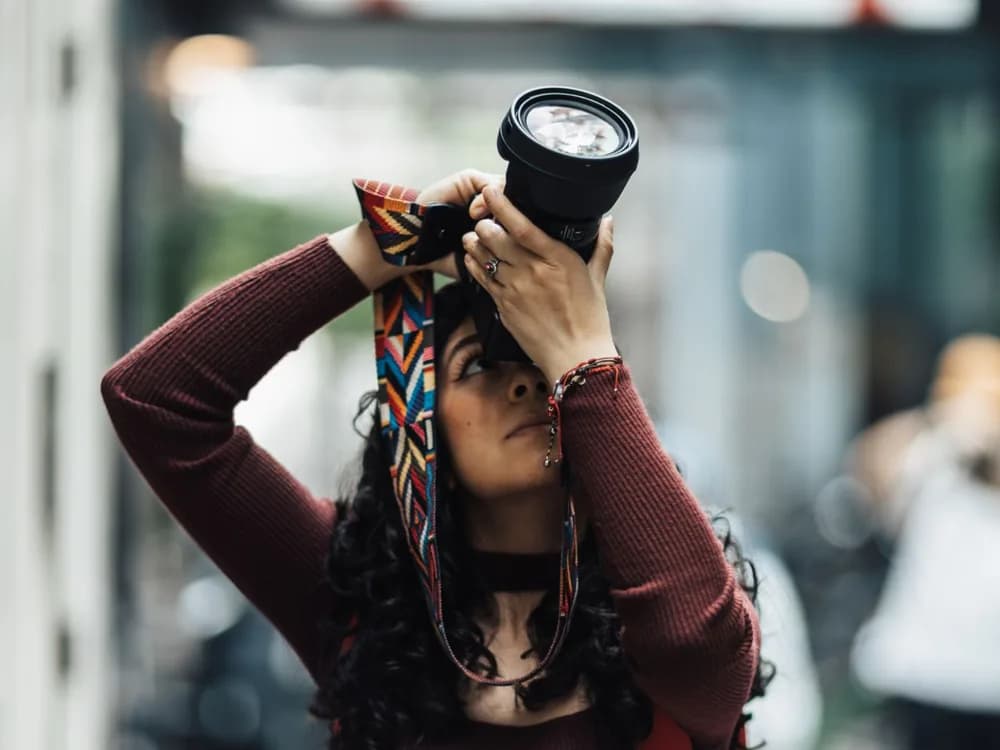 Fotógrafa buscando un encuadre durante un paseo por la ciudad